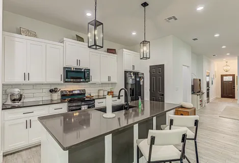 a kitchen with stainless steel appliances granite countertop a sink a stove and a refrigerator