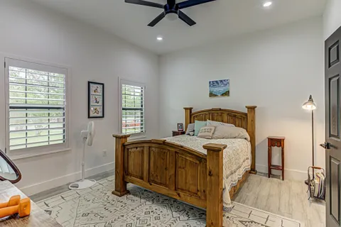 a bedroom with a large bed and wooden floor