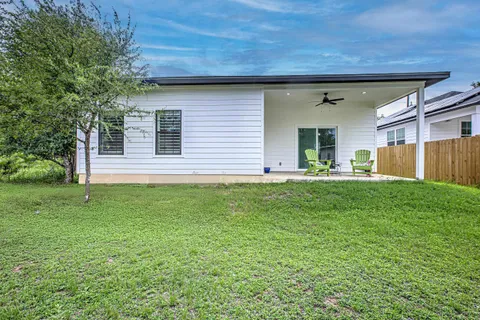 a view of a house with a backyard and a patio