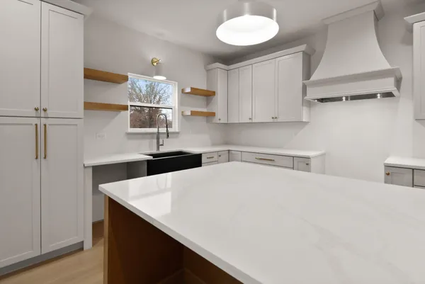 a kitchen with a sink a counter space and cabinets
