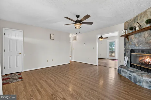 an empty room with wooden floor closet and windows