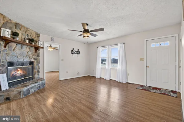 a view of an empty room with window and ceiling fan