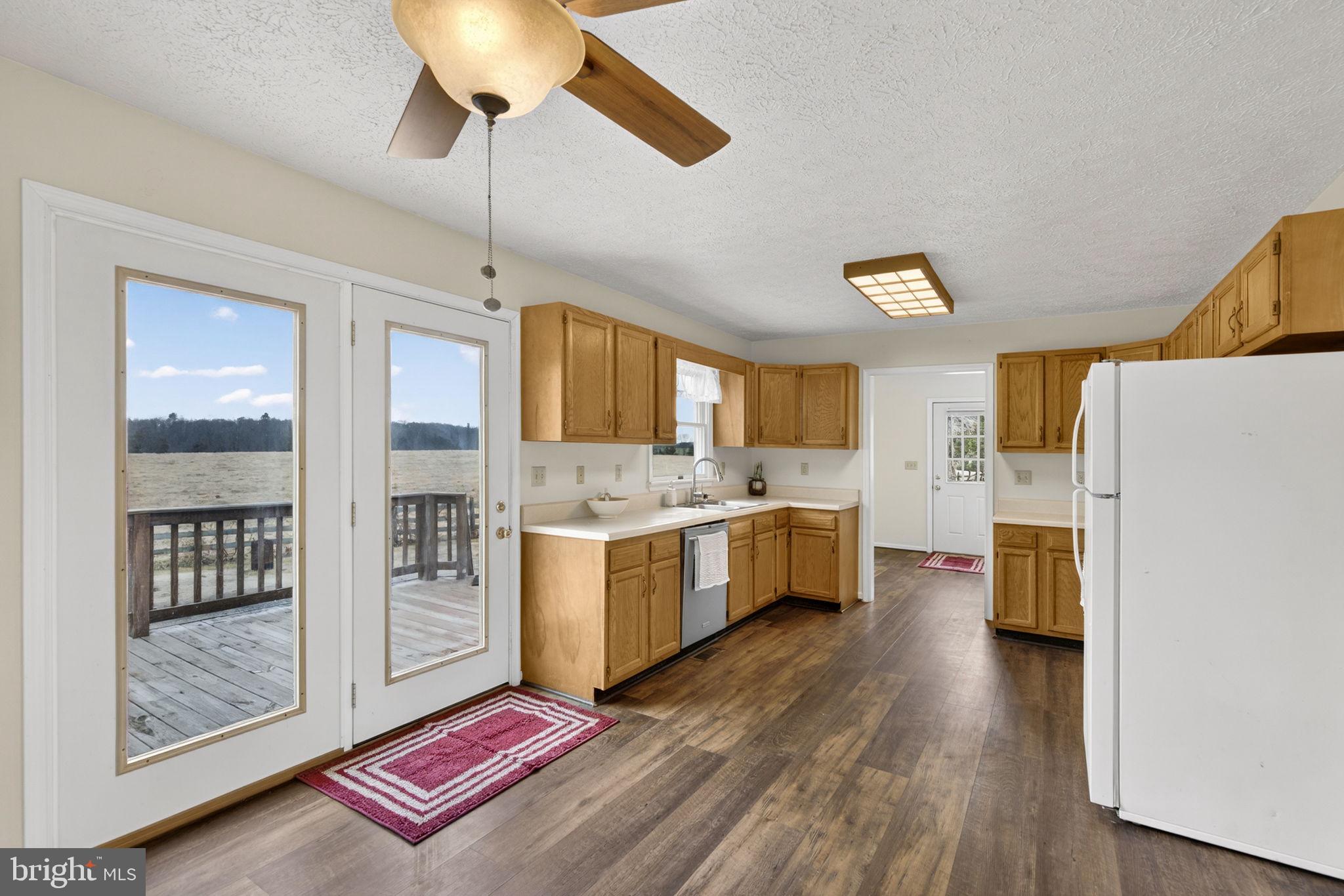 11576 Walters Road Orange, VA 22960 - Photo 21 of 61 a kitchen with stainless steel appliances kitchen island granite countertop a refrigerator a stove a sink dishwasher and white cabinets with wooden floor