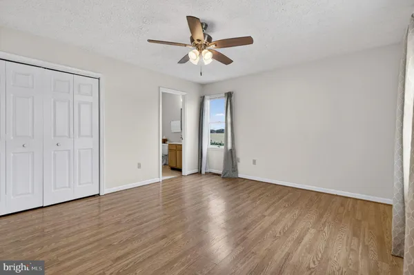 a bathroom with a granite countertop toilet sink and mirror