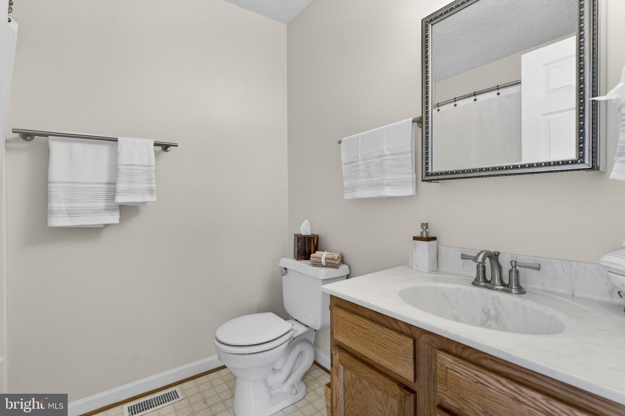 11576 Walters Road Orange, VA 22960 - Photo 31 of 61 a bathroom with a granite countertop toilet sink and mirror