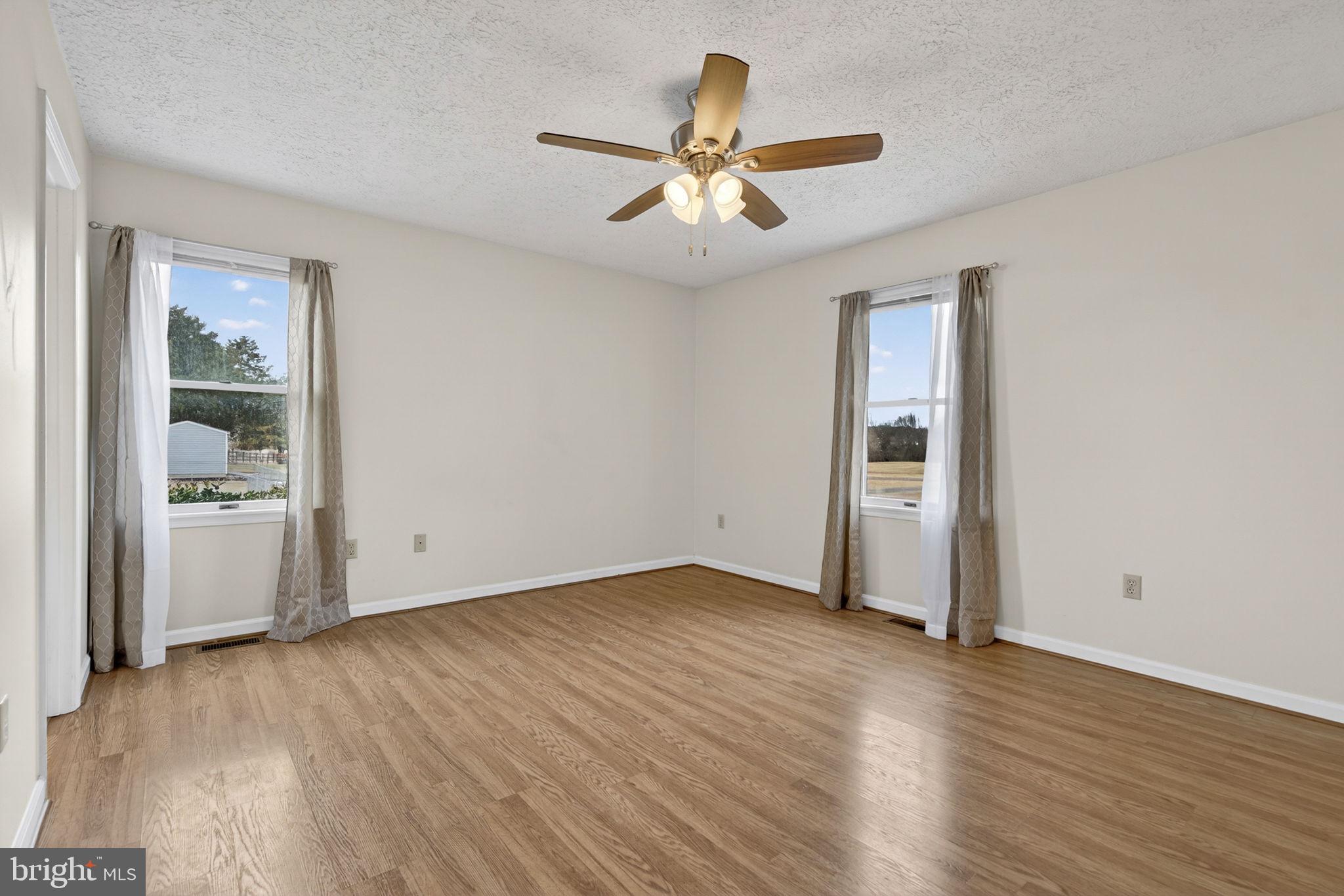 11576 Walters Road Orange, VA 22960 - Photo 32 of 61 an empty room with wooden floor a ceiling fan and windows