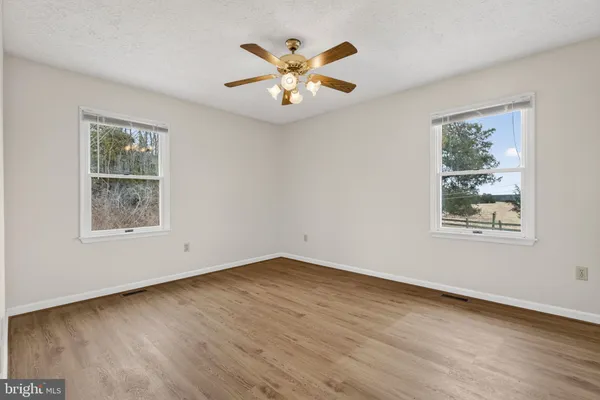 a view of an empty room with wooden floor