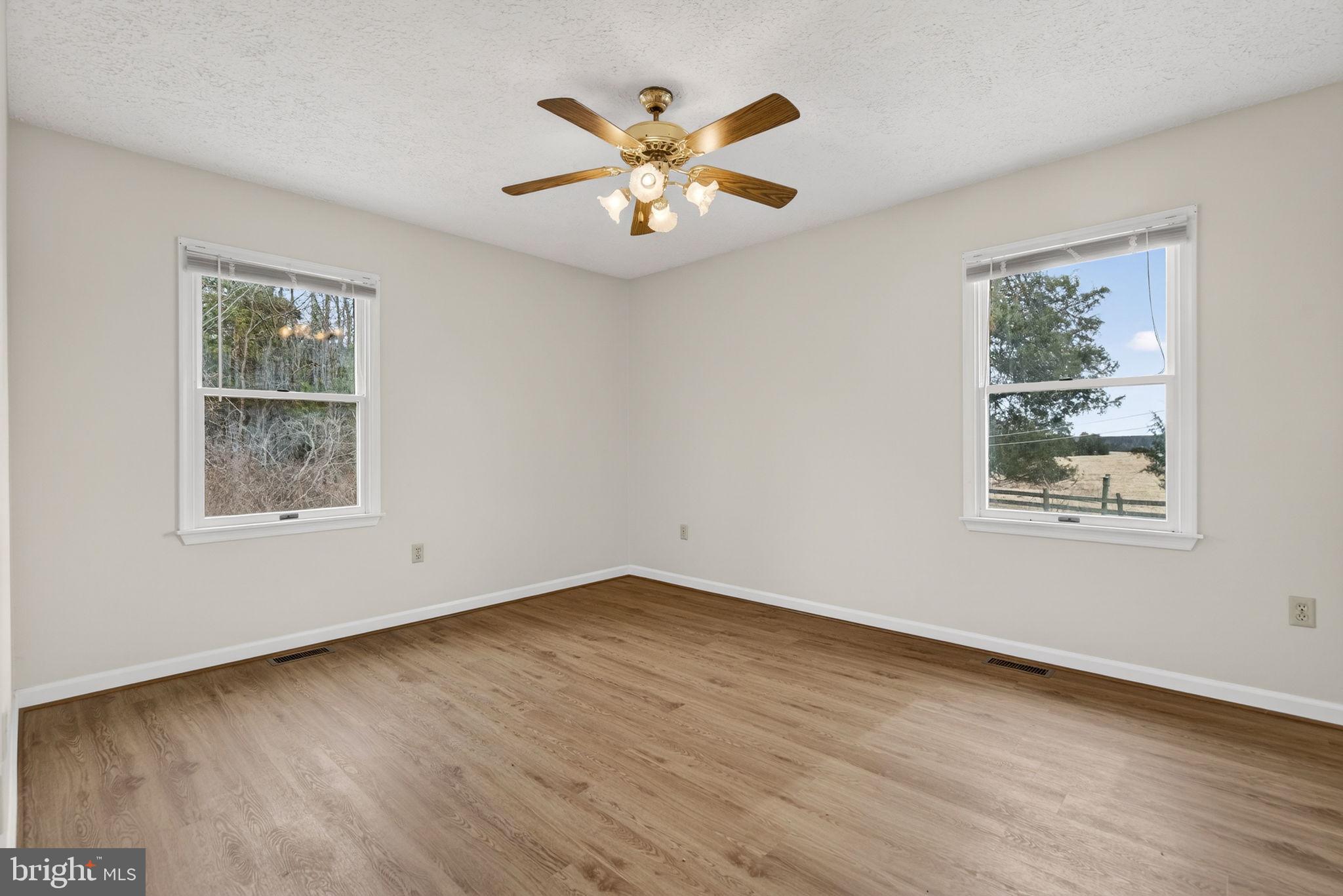 11576 Walters Road Orange, VA 22960 - Photo 36 of 61 a view of an empty room with wooden floor and a ceiling fan