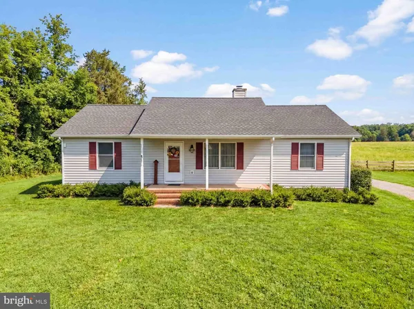 a view of a house with a backyard and a tree