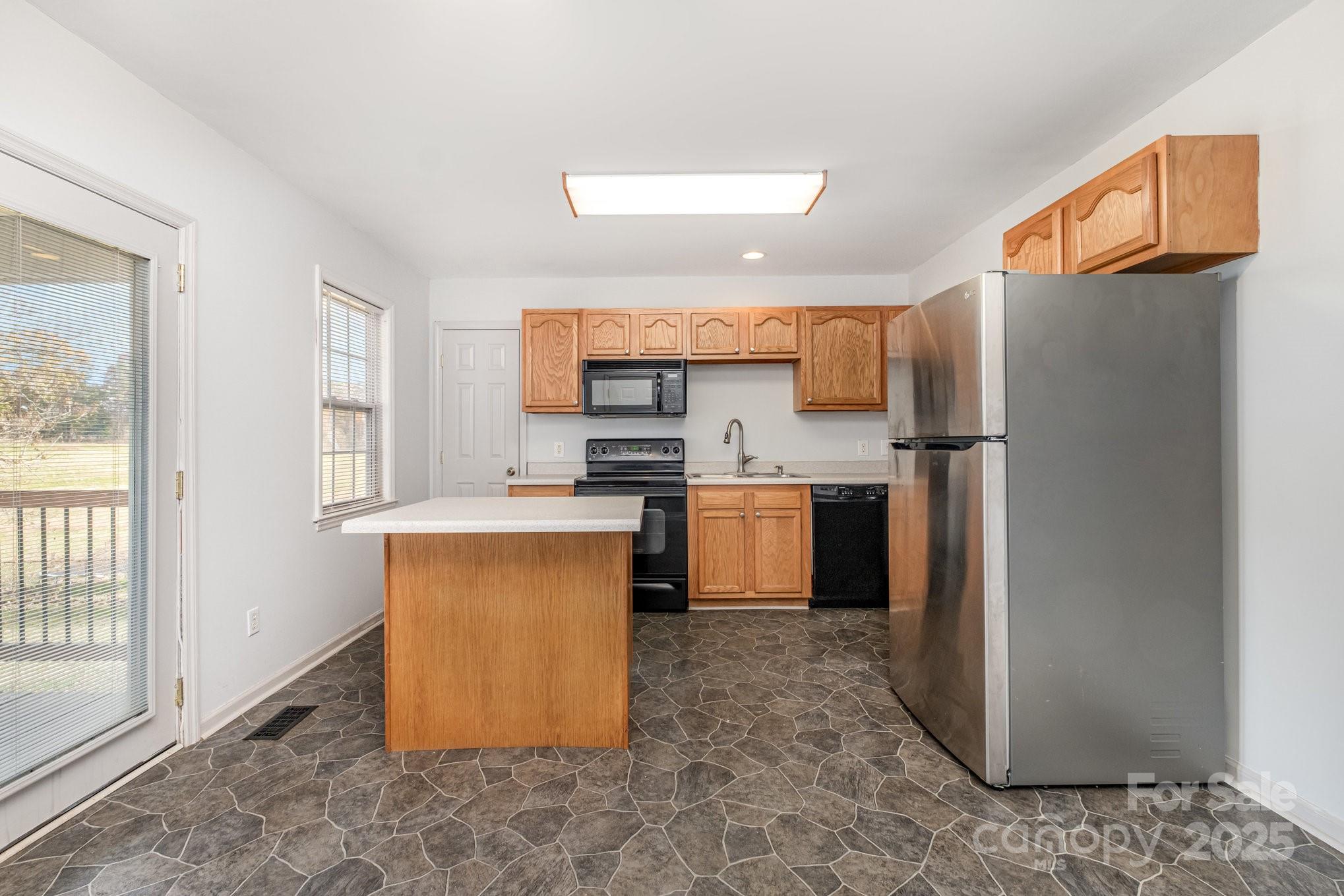 4980 Forest Ridge Drive Hickory, NC 28602 - Photo 13 of 35 a kitchen with stainless steel appliances granite countertop a refrigerator a stove a sink and a window