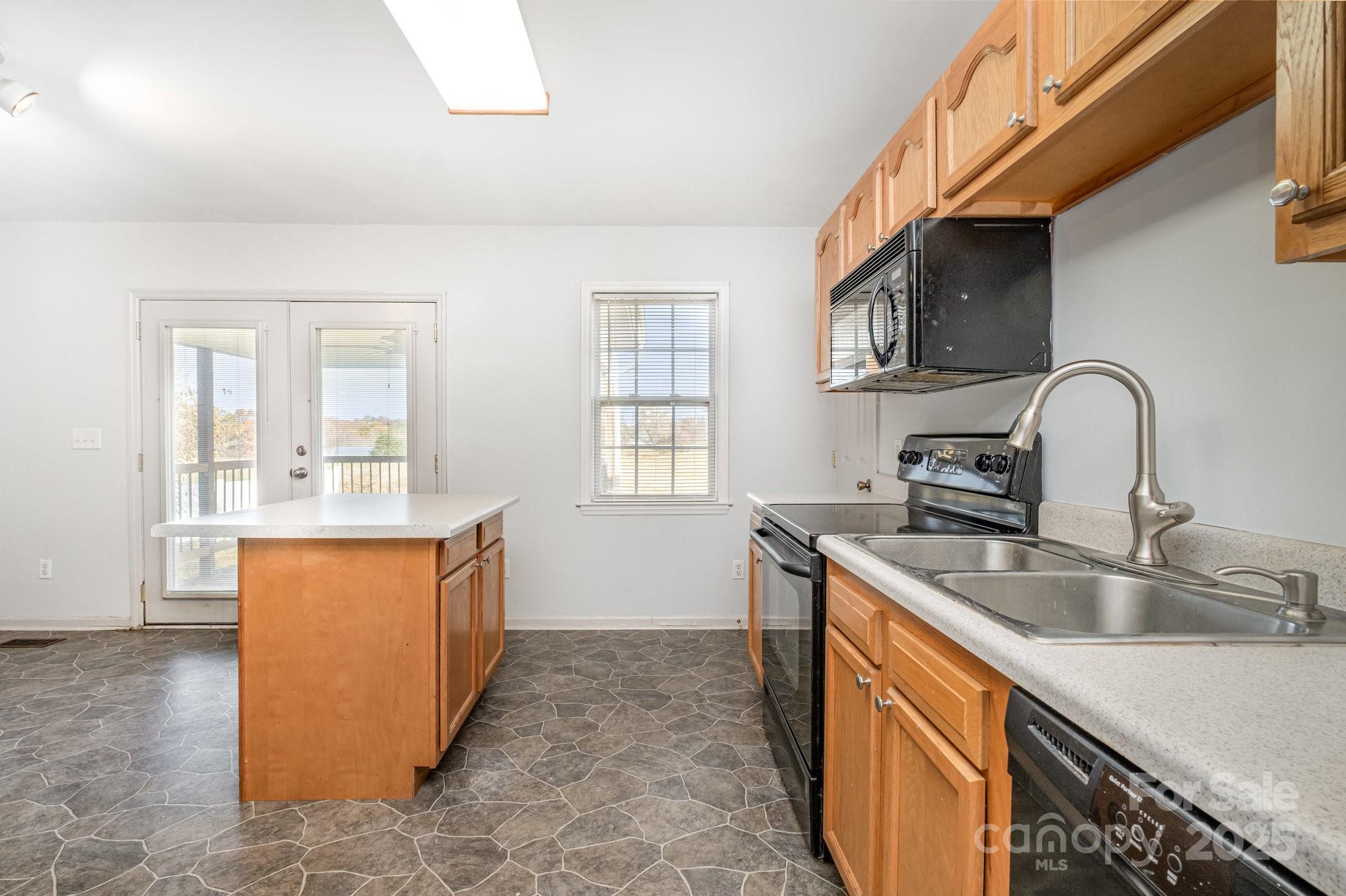 4980 Forest Ridge Drive Hickory, NC 28602 - Photo 14 of 35 a kitchen with stainless steel appliances granite countertop a sink and dishwasher a stove top oven with wooden floor