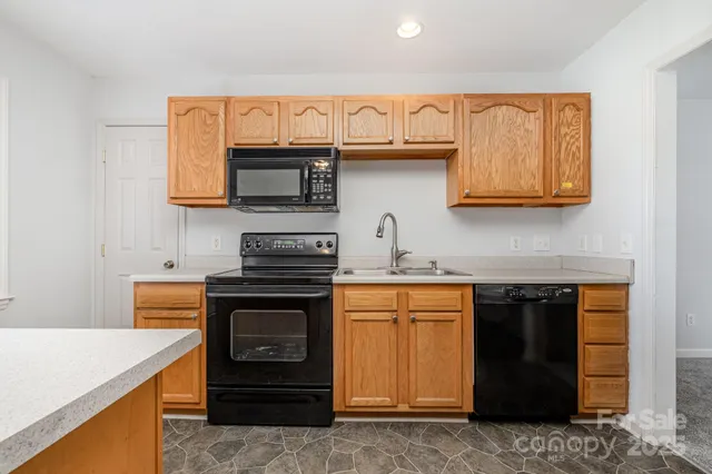 a kitchen with granite countertop a stove top oven microwave and cabinets