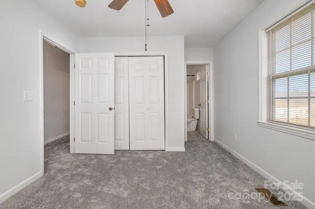 an empty room with windows and closet