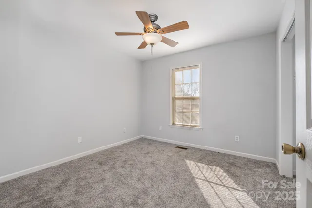 an empty room with fan and windows