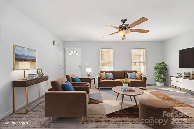 a living room with furniture a window and a flat screen tv