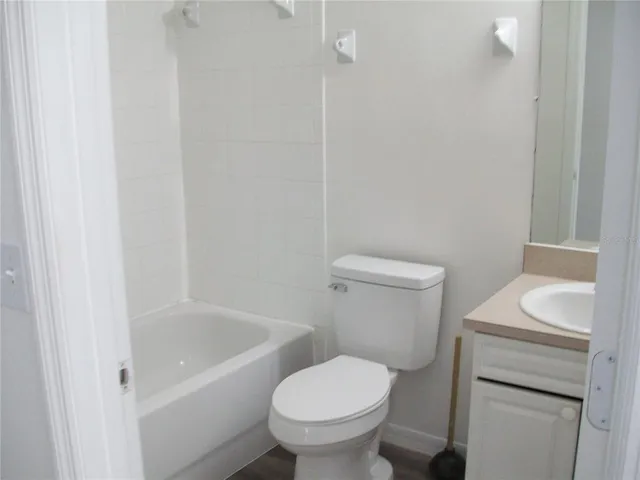 a white toilet sitting next to a white bath tub