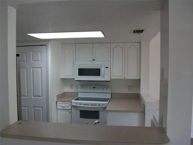 a kitchen with cabinets and steel appliances