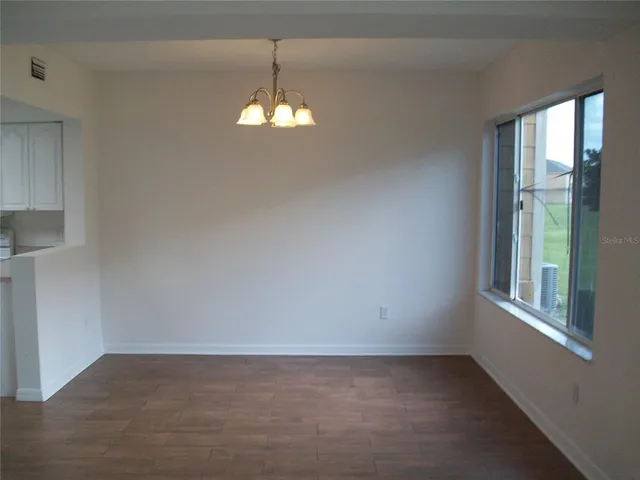an empty room with windows and chandelier