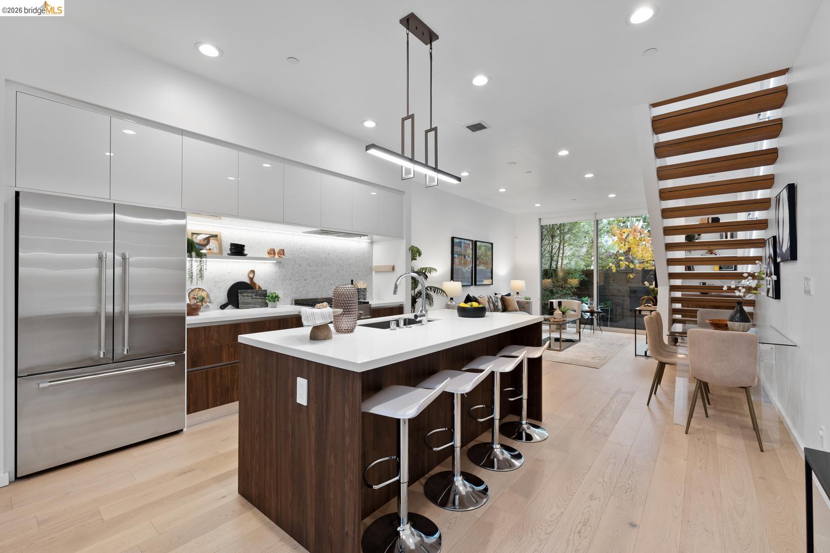 Kitchen featuring modern cabinets, built in refrigerator, white cabinets, a kitchen bar, and recessed lighting