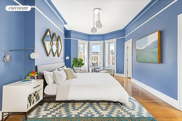 a bedroom with a bed wooden floor and window