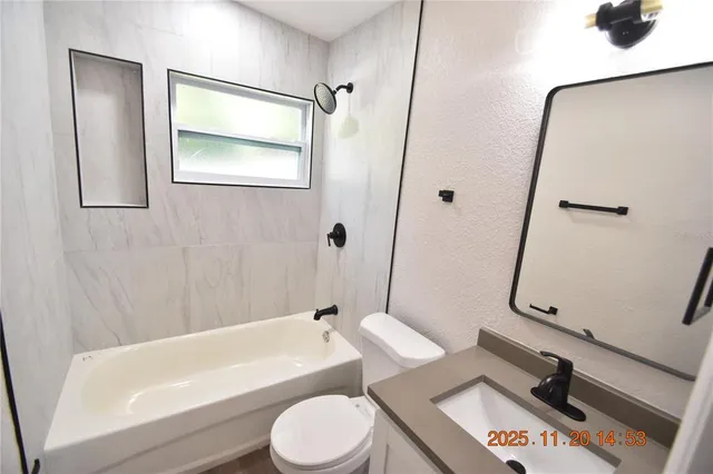 a view of a house with a yard and large tree