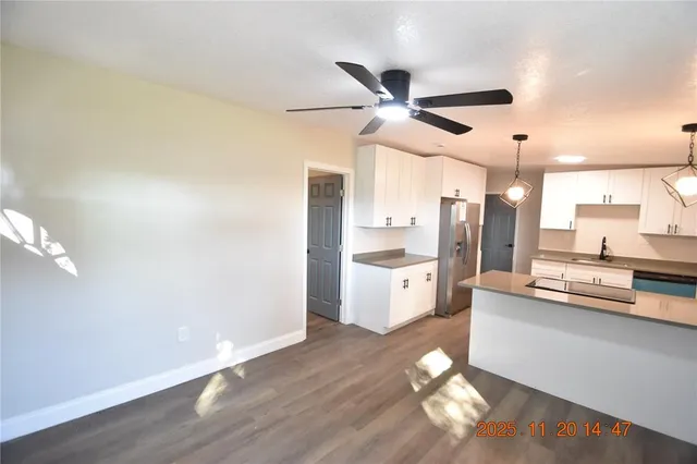 a kitchen with kitchen island white cabinets and wooden floor