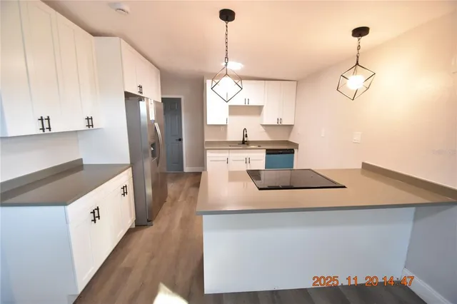 a kitchen with white cabinets and refrigerator