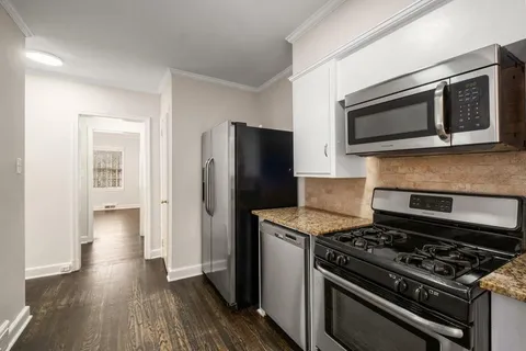 a kitchen with stainless steel appliances and a wooden floor