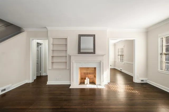 a view of empty room with wooden floor and fireplace