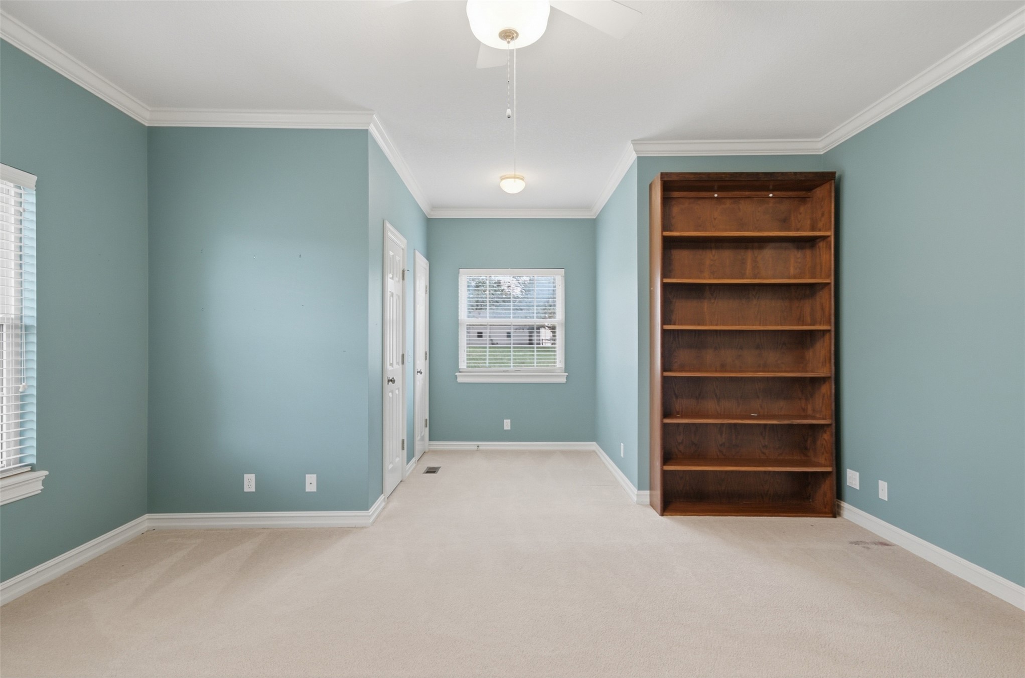17875 East 589 Road Inola, OK 74036 - Photo 30 of 73 Built-in wood-finish shelving, wall-to-wall carpeting, crown molding, white trim, and a ceiling fan with integrated lighting, and walk in closet