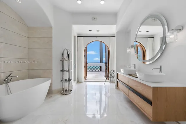 a spacious bathroom with a tub sink and mirror