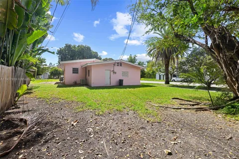 a view of a house with a yard and large trees