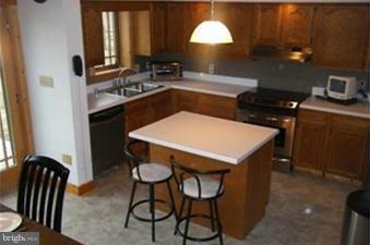 9013 Old Mill Road Rocky Ridge, MD 21778 - Photo 9 of 16 a kitchen with a table chairs stove and cabinets
