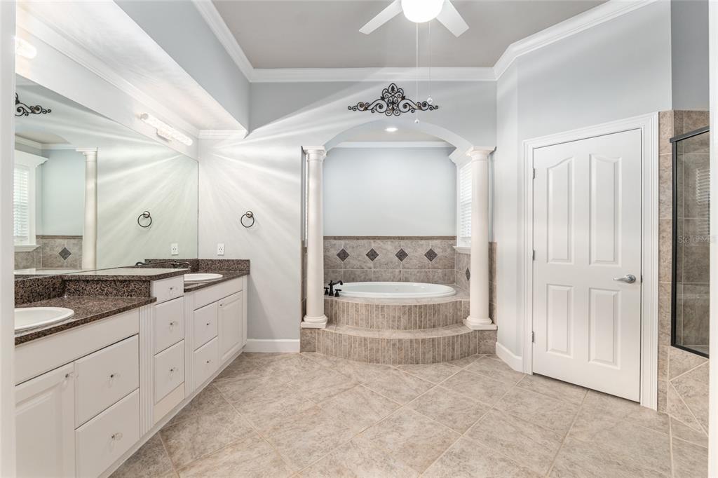 10614 Southwest 15th Lane Gainesville, FL 32607 - Photo 33 of 85 a spacious bathroom with a granite countertop sink a toilet a mirror and shower