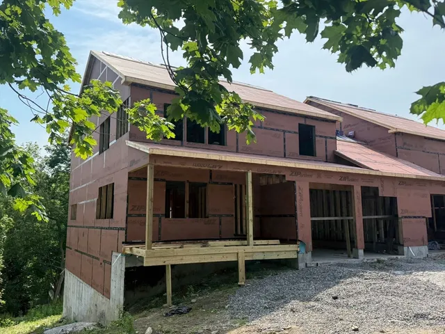 a view of a house with a large window and a large tree