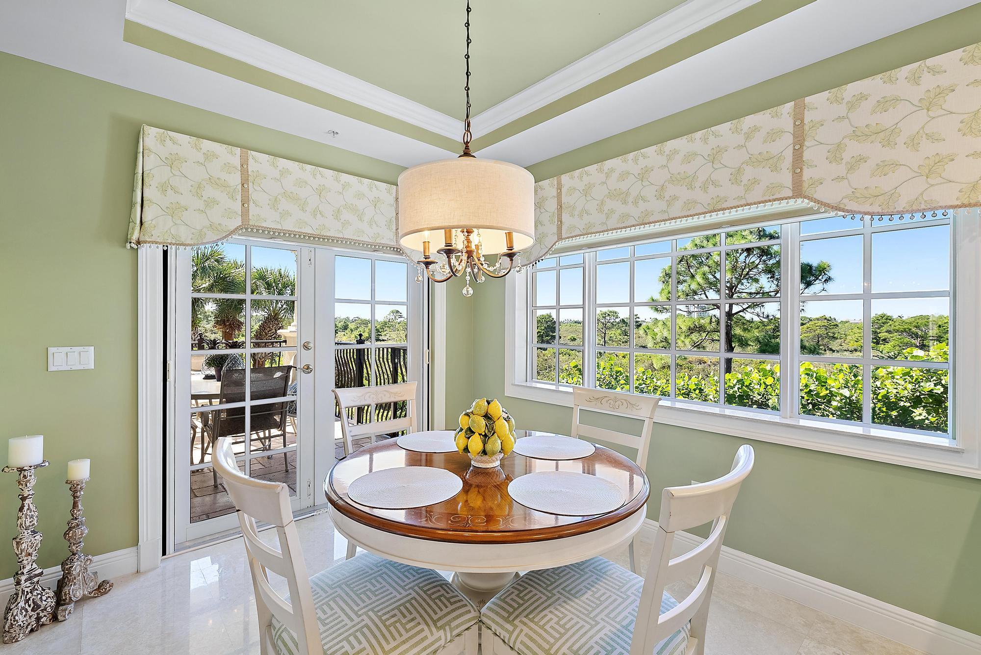 126 Tierra Lane, Unit 2 Jupiter, FL 33477 - Photo 18 of 59 a dining room with furniture a chandelier and wooden floor