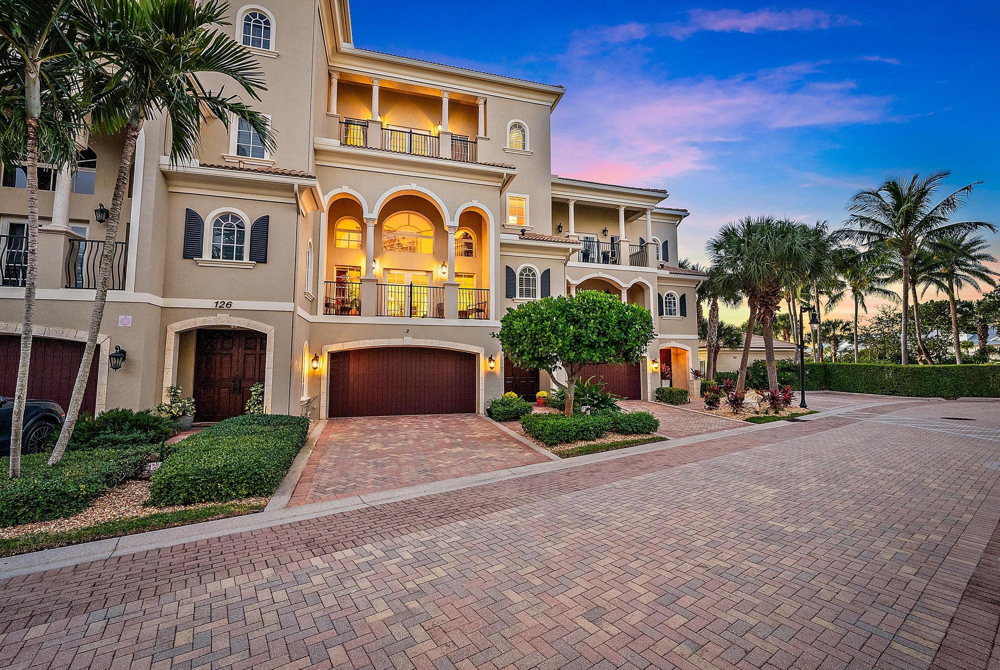 126 Tierra Lane, Unit 2 Jupiter, FL 33477 - Photo 2 of 59 a front view of a house with garden and parking