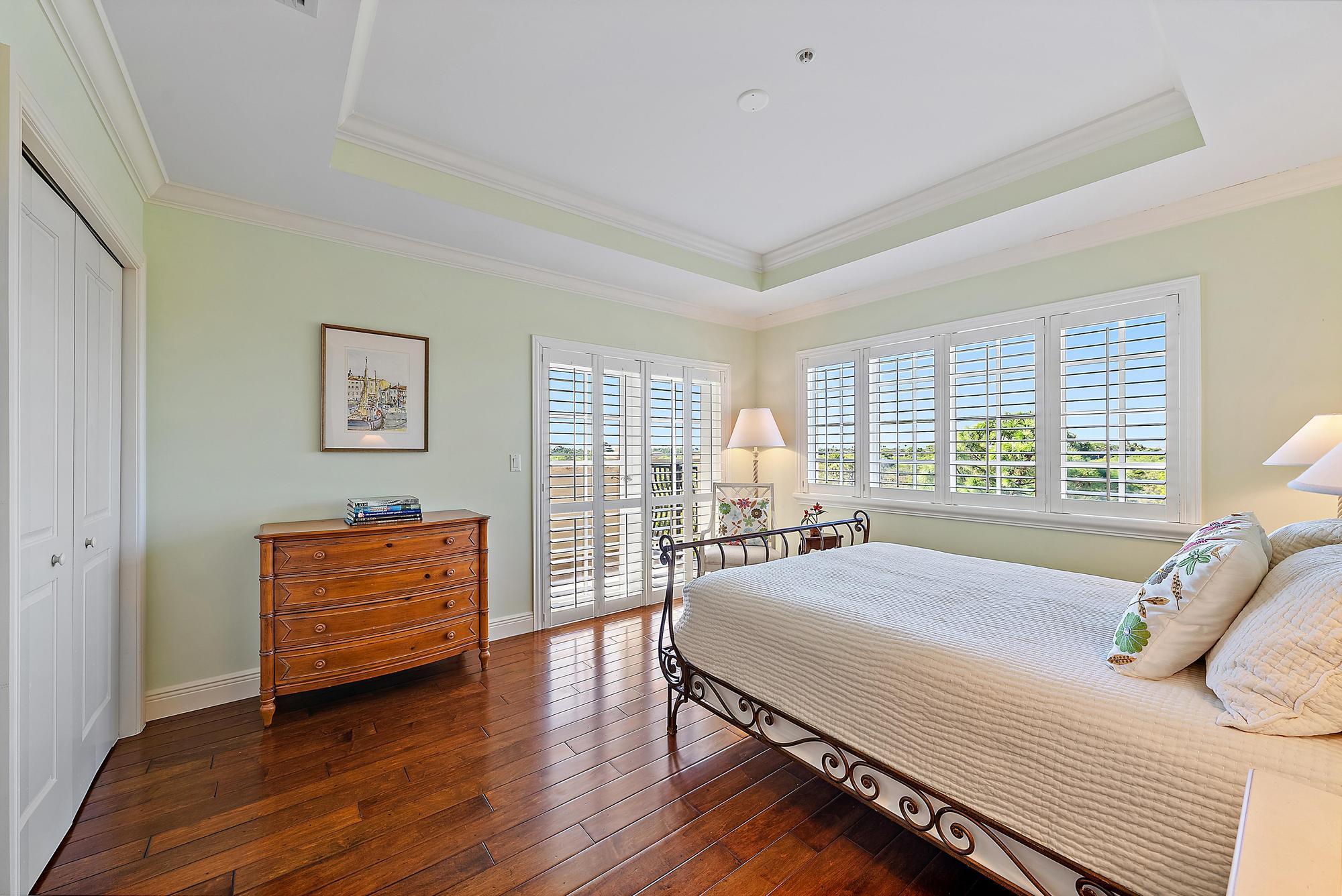 126 Tierra Lane, Unit 2 Jupiter, FL 33477 - Photo 30 of 59 a bedroom with a bed and a chair