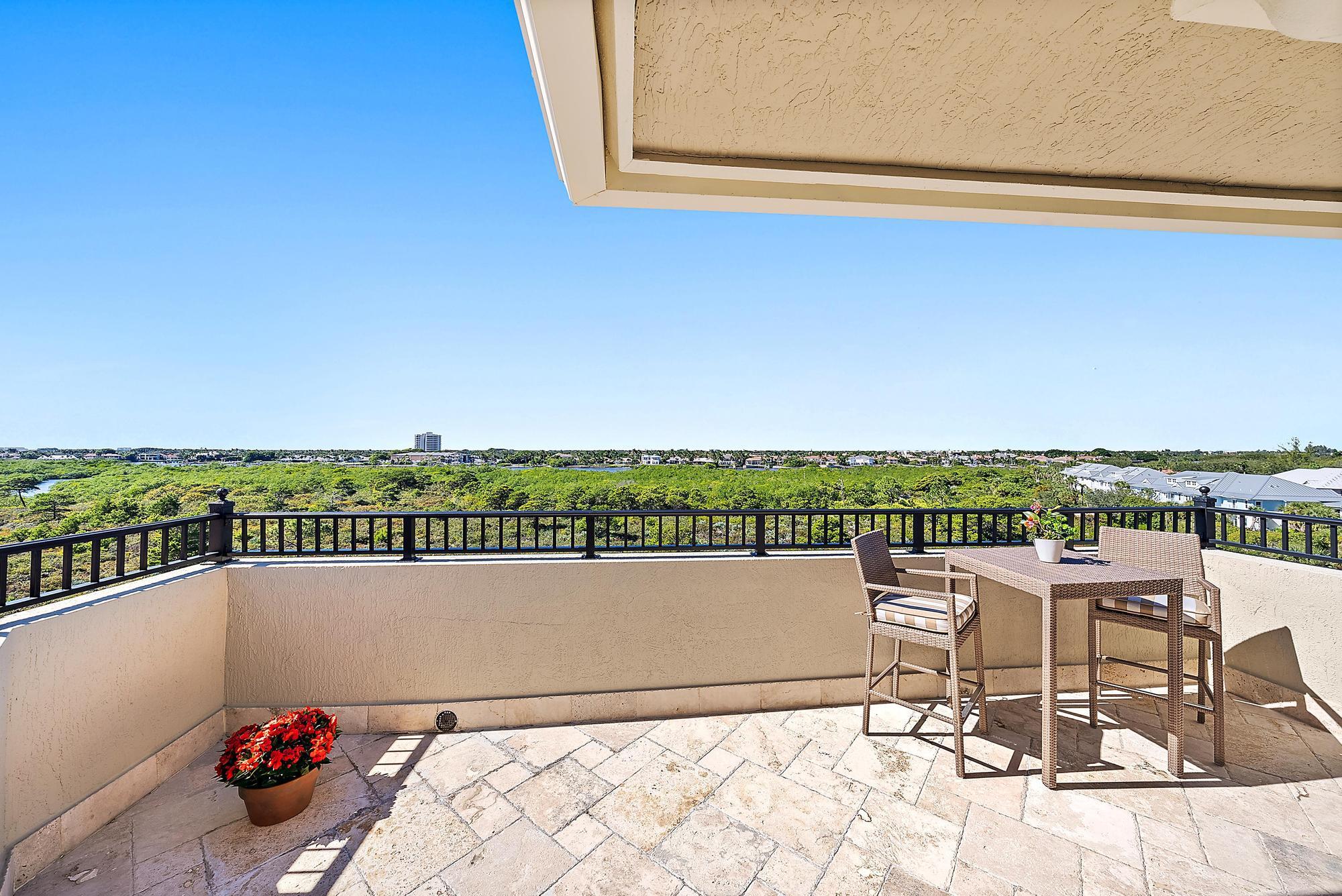 126 Tierra Lane, Unit 2 Jupiter, FL 33477 - Photo 46 of 59 a view of a chairs and table on the terrace