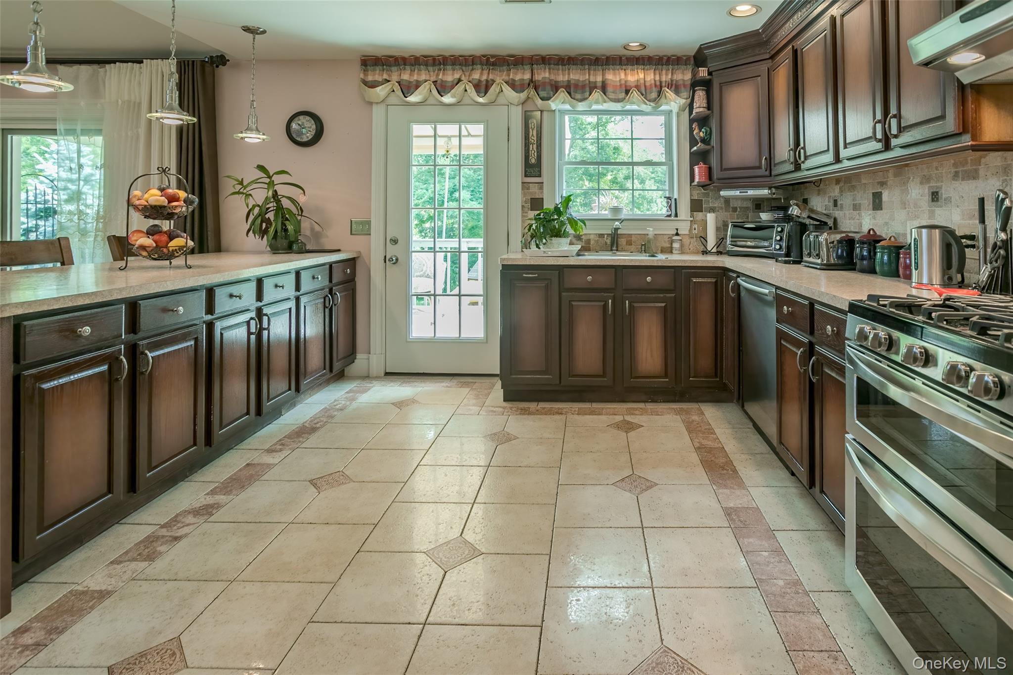 300 Mountain Lodge Road Monroe, NY 10950 - Photo 5 of 41 Kitchen with stainless steel appliances, inlaid floor details, ventilation hood, dark wood finish cabinets, and light tile patterned floors