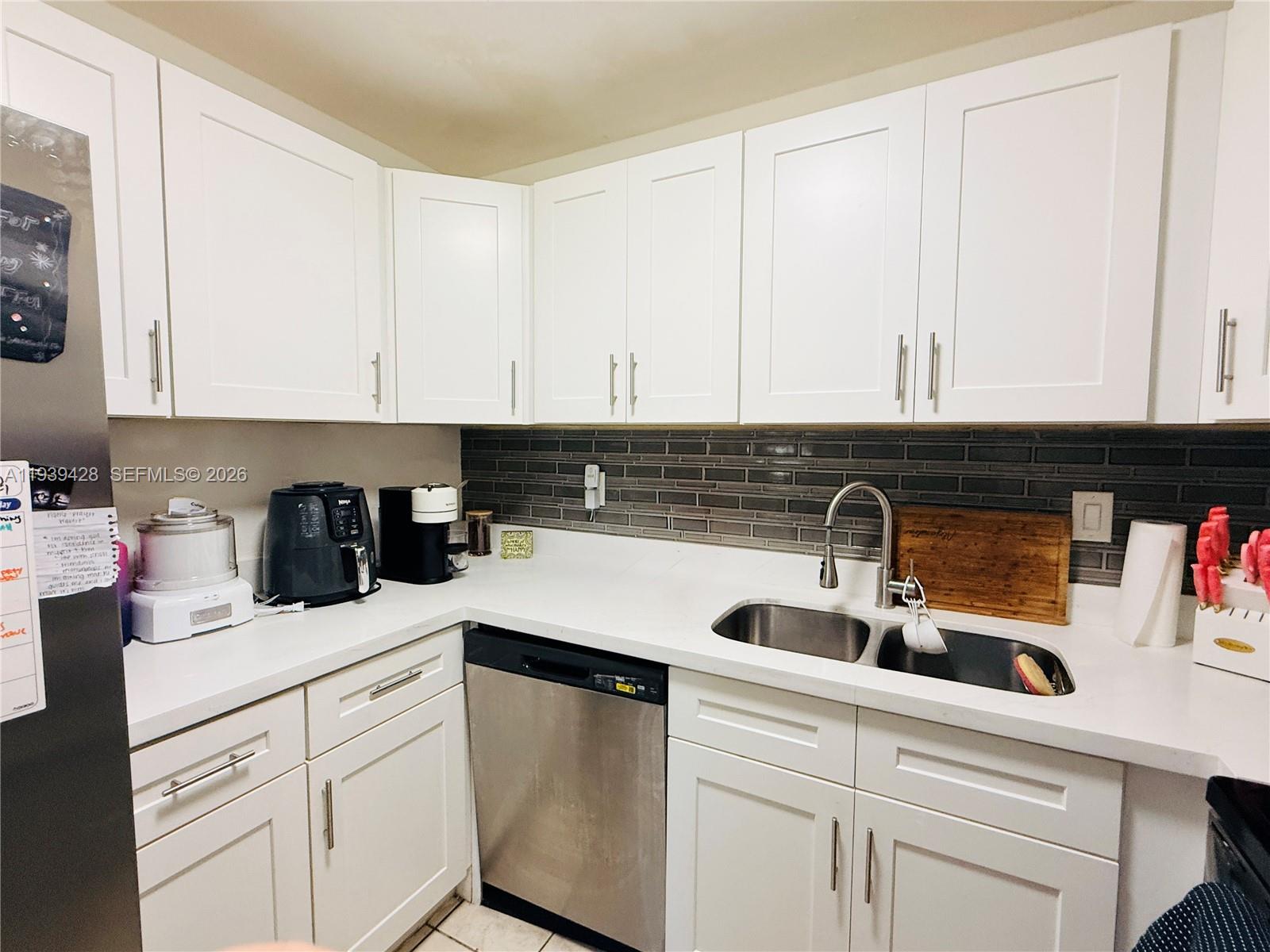 2651 Riverside Drive, Unit 3 Coral Springs, FL 33065 - Photo 11 of 29 a kitchen with white cabinets and sink
