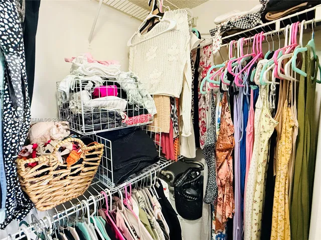 a view of walk in closet with clothes and shoes