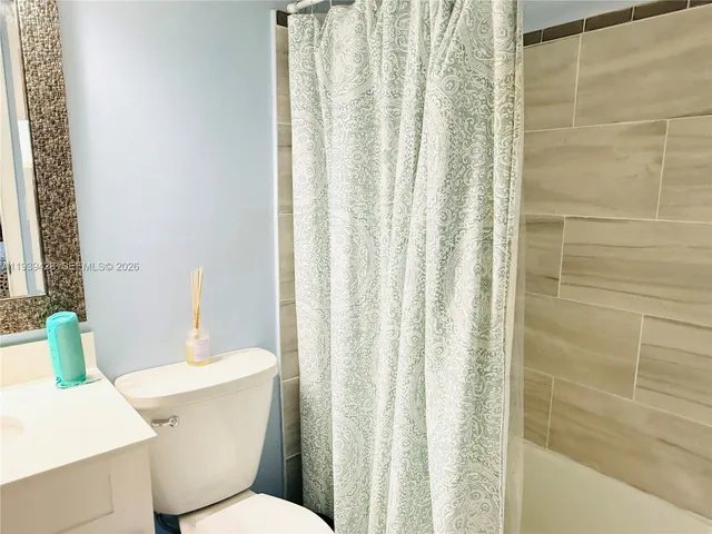 a white toilet sitting next to a bathroom sink