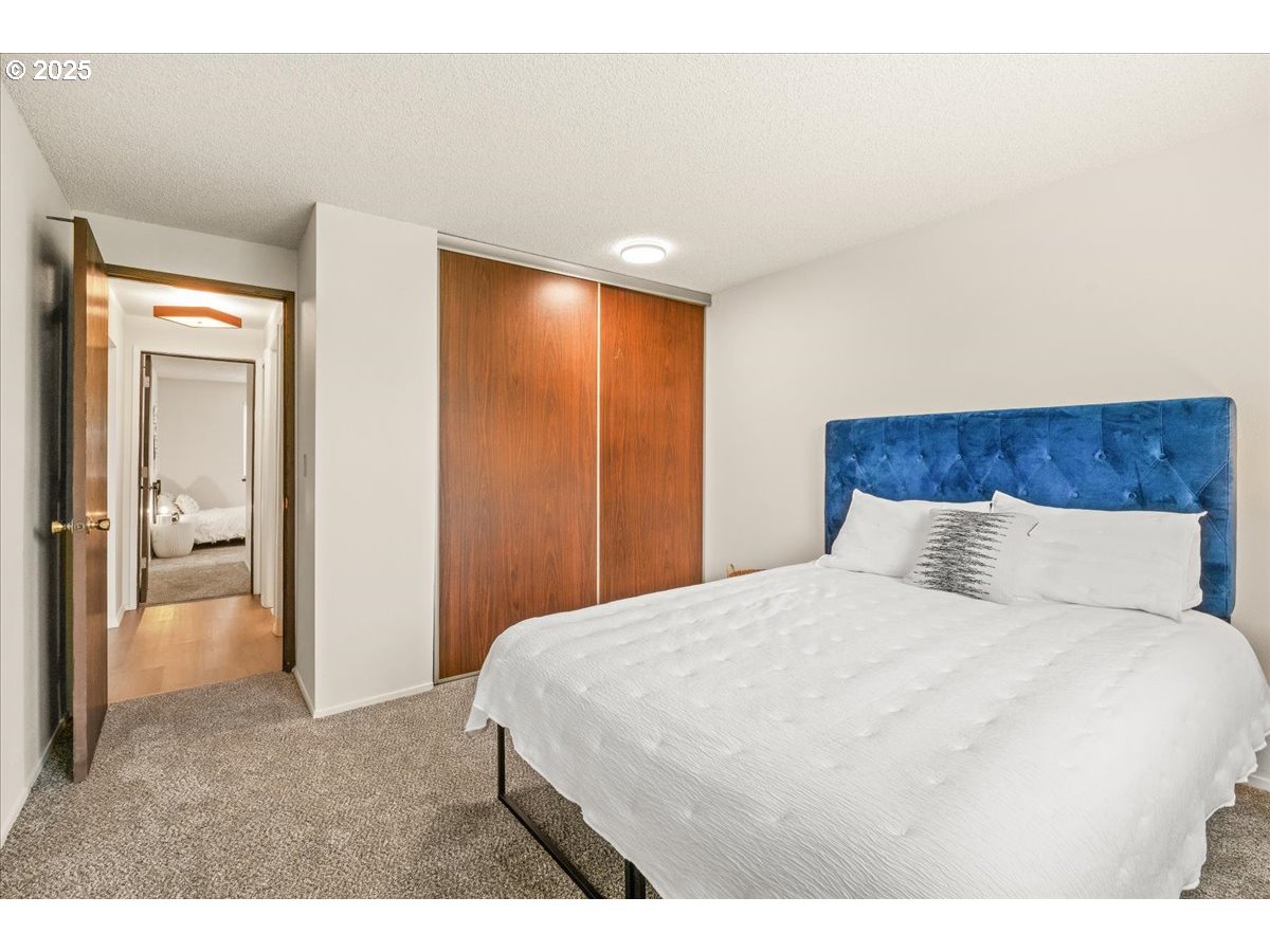 12612 Northwest Barnes Road, Unit 6 Portland, OR 97229 - Photo 19 of 40 a bedroom with a large bed and a chandelier