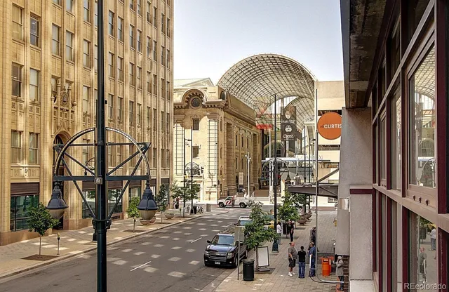a man walking down a street next to a building