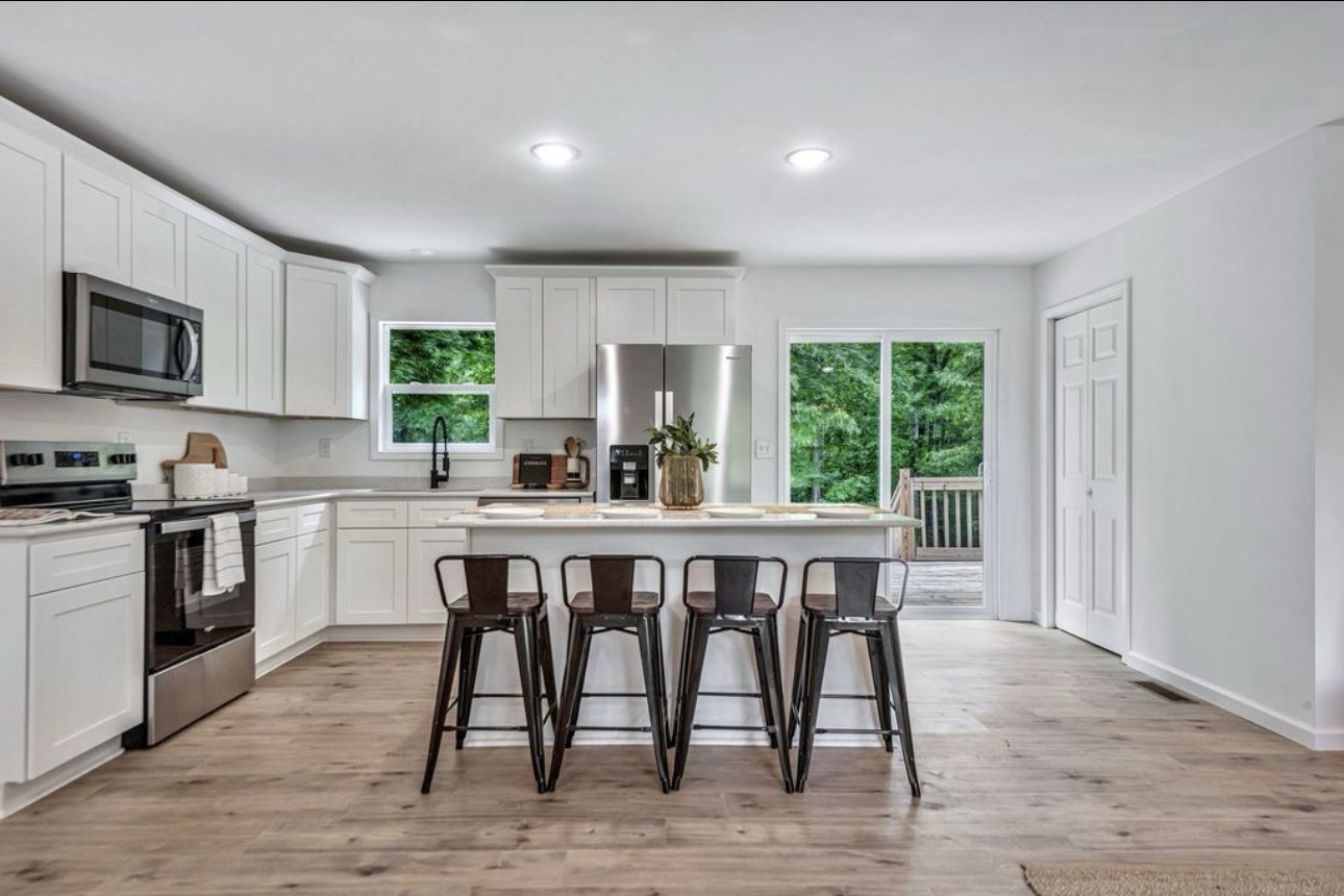 10498 Missionary Ridge Road Bon Aqua, TN 37025 - Photo 13 of 41 a kitchen with a table chairs microwave and cabinets
