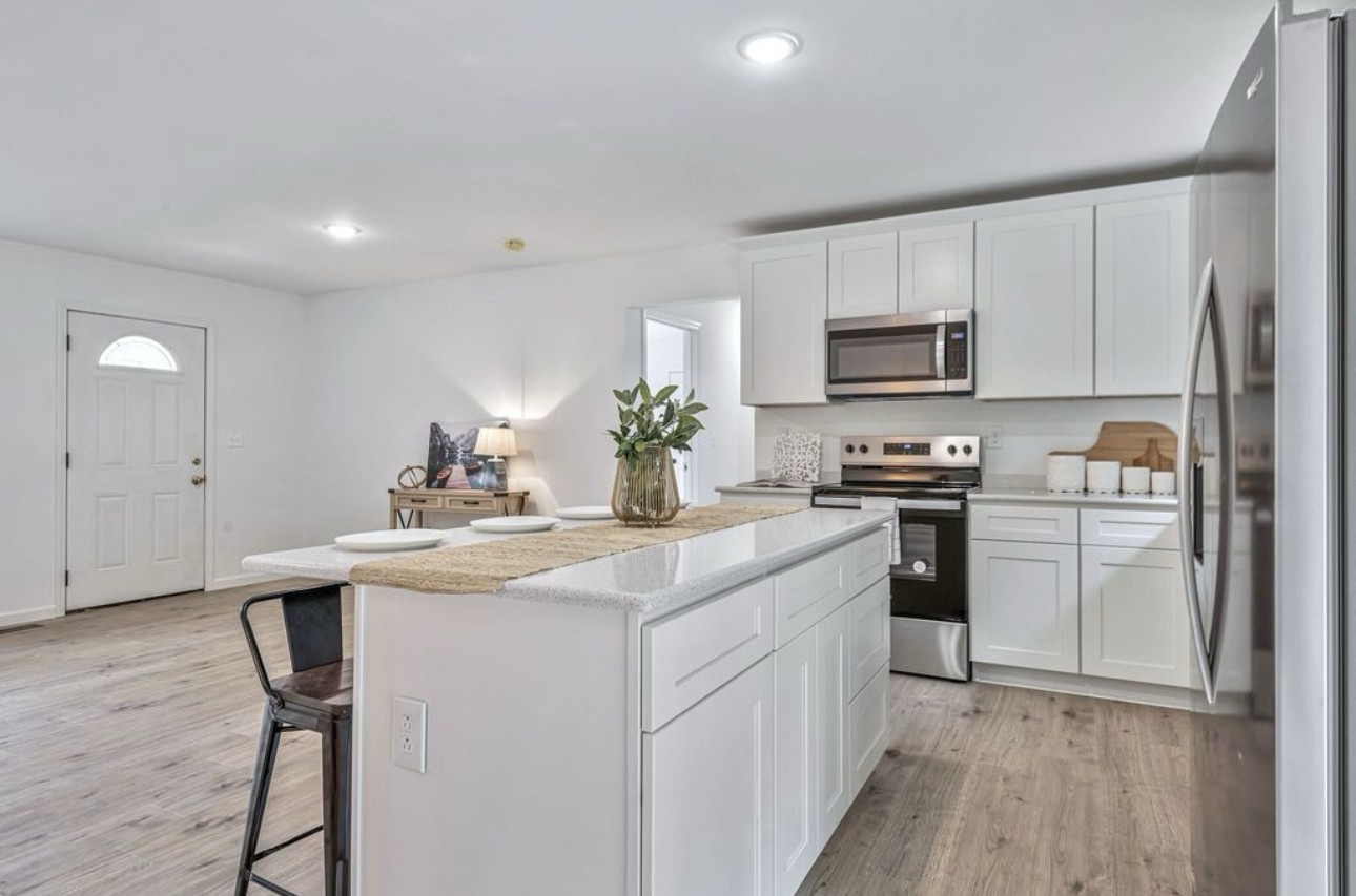 10498 Missionary Ridge Road Bon Aqua, TN 37025 - Photo 19 of 41 a kitchen with kitchen island white cabinets appliances and sink