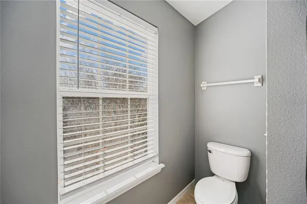a bathroom with a toilet and a window
