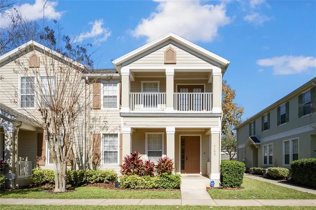 a view of a brick house with many windows next to a yard