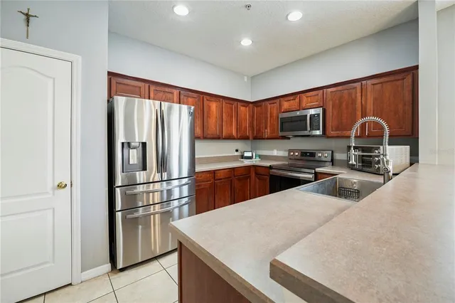 a kitchen with granite countertop a refrigerator stove top oven a sink and dishwasher